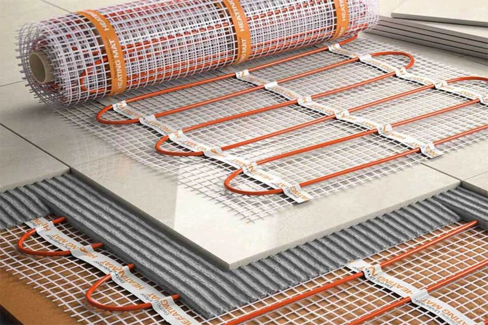 Монтаж електричної теплої підлоги в сучасному інтер'єрі — кабелі, термостат і покриття з плитки.