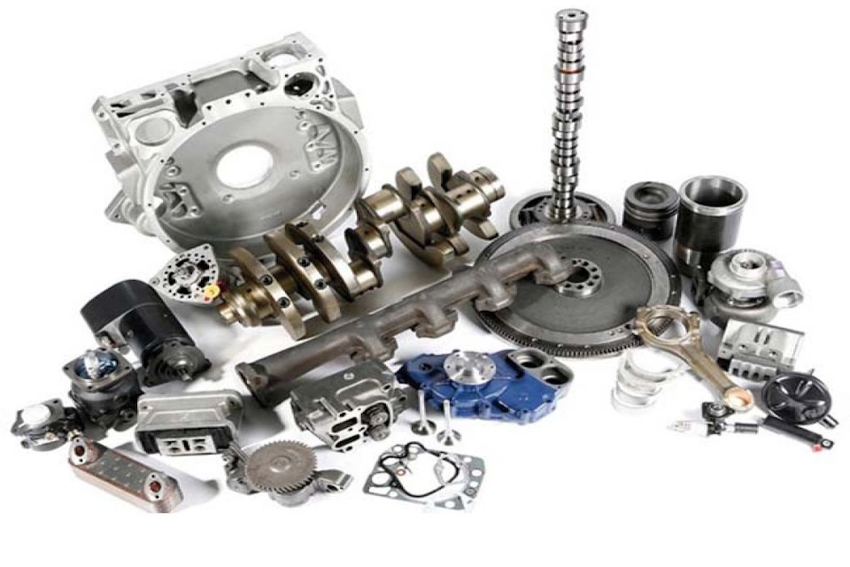 Комплект запчастин для мотоблока — ремені, фільтри, свічки та редуктор, розкладені на робочому столі; символ надійності, технічної точності й догляду за технікою.